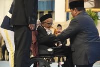 Presiden Prabowo saat mengalungkan medali penghargaan kepada Teungku Nyak Sandang, penyumbang pembelian pesawat pertama RI. (BPMI Setpres)