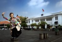 Seorang penari Jaipong dengan kostum tradisional yang cerah menampilkan kelenturan gerak tubuhnya, memancarkan pesona dan semangat khas budaya Sunda yang dinamis dan ekspresif. Pertunjukan ini menjadi simbol hidupnya warisan budaya di tengah arus modernisasi.