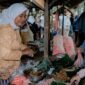 Seorang wanita modern menikmati segelas jamu kunyit asam segar di sebuah kafe jamu kekinian, menunjukkan bagaimana minuman tradisional ini telah beradaptasi dengan gaya hidup urban. Berbagai rempah seperti jahe, kunyit, dan kencur yang menjadi bahan dasar jamu tampak tertata rapi di latar belakang, mengisyaratkan kekayaan alam Indonesia.