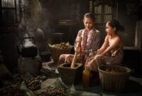 Seorang penjual jamu gendong tengah menyajikan ramuan kunyit asam yang segar, menampilkan kekayaan tradisi kuliner dan kesehatan Indonesia yang sudah ada sejak ratusan tahun silam.