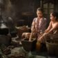 Seorang penjual jamu gendong tengah menyajikan ramuan kunyit asam yang segar, menampilkan kekayaan tradisi kuliner dan kesehatan Indonesia yang sudah ada sejak ratusan tahun silam.
