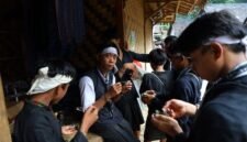 Seorang nenek di pedesaan Sunda sedang meracik ramuan herbal menggunakan tumbuk tradisional, menunjukkan kearifan turun-temurun dalam mengolah tanaman obat alami. Berbagai jenis dedaunan dan akar terlihat di sekelilingnya, siap diolah menjadi obat untuk menjaga kesehatan.