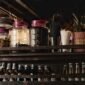 Suasana nyaman sebuah kafe jamu modern yang menyajikan ramuan herbal tradisional Indonesia dengan sentuhan kekinian, menarik minat generasi muda untuk menikmati manfaat kesehatan alami. Berbagai botol jamu dengan kemasan menarik tertata rapi, menunjukkan evolusi minuman warisan budaya ini agar tetap relevan dengan gaya hidup urban.