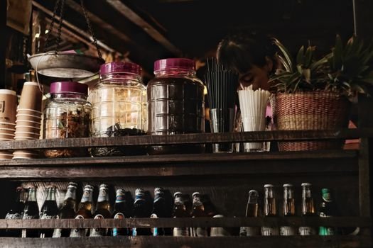 Suasana nyaman sebuah kafe jamu modern yang menyajikan ramuan herbal tradisional Indonesia dengan sentuhan kekinian, menarik minat generasi muda untuk menikmati manfaat kesehatan alami. Berbagai botol jamu dengan kemasan menarik tertata rapi, menunjukkan evolusi minuman warisan budaya ini agar tetap relevan dengan gaya hidup urban.