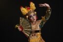 Seorang penari Jaipong dengan kostum warna-warni yang cerah sedang menampilkan gerakan lincah penuh ekspresi, diiringi alunan musik gamelan khas Sunda. Tarian ini melambangkan semangat dan kekayaan budaya Indonesia yang terus lestari.