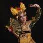 Seorang penari Jaipong dengan kostum warna-warni yang cerah sedang menampilkan gerakan lincah penuh ekspresi, diiringi alunan musik gamelan khas Sunda. Tarian ini melambangkan semangat dan kekayaan budaya Indonesia yang terus lestari.