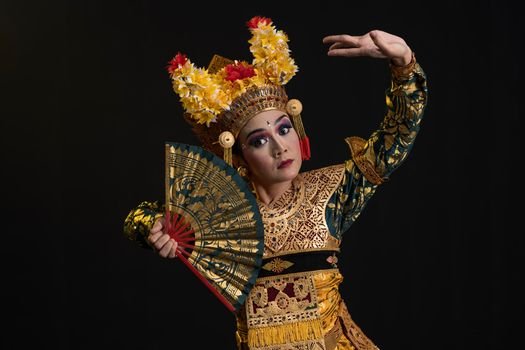 Seorang penari Jaipong dengan kostum warna-warni yang cerah sedang menampilkan gerakan lincah penuh ekspresi, diiringi alunan musik gamelan khas Sunda. Tarian ini melambangkan semangat dan kekayaan budaya Indonesia yang terus lestari.