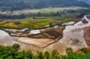Pemandangan udara Sungai Citarum yang menunjukkan perbaikan signifikan, dengan air yang mulai jernih dan aktivitas pembersihan yang terus berlangsung. Gambar ini merefleksikan hasil kerja keras ribuan relawan dan berbagai pihak dalam upaya revitalisasi Citarum Harum.