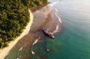 Pemandangan matahari terbenam yang memukau di Pantai Pangandaran, dengan siluet perahu nelayan tradisional yang menambah keindahan suasana senja. Pengunjung juga dapat menikmati keseruan *body rafting* di Green Canyon atau menyelami keindahan bawah laut di Pasir Putih Pangandaran.