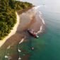 Pemandangan matahari terbenam yang memukau di Pantai Pangandaran, dengan siluet perahu nelayan tradisional yang menambah keindahan suasana senja. Pengunjung juga dapat menikmati keseruan *body rafting* di Green Canyon atau menyelami keindahan bawah laut di Pasir Putih Pangandaran.