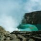 Pemandangan udara Kawah Putih Ciwidey yang menakjubkan, menunjukkan danau kawah berwarna putih kehijauan dikelilingi lanskap pegunungan yang asri. Visual ini memperlihatkan keunikan geologis dan keindahan alam yang menjadi daya tarik utama destinasi wisata populer tersebut.