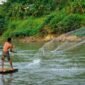 Para pekerja dan relawan secara aktif membersihkan sampah serta sedimen di salah satu titik Sungai Citarum, menunjukkan komitmen nyata dalam upaya restorasi lingkungan sungai legendaris ini. Pemandangan ini merefleksikan harapan baru bagi masa depan Citarum yang lebih bersih dan sehat.