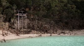 Pemandangan Kawah Putih Ciwidey dengan danau berwarna pirus kehijauan yang kontras dengan tebing kapur putih, menciptakan lanskap surealistik memukau. Udara sejuk pegunungan dan aroma belerang khas menambah pengalaman unik saat menjelajahi keindahan alam ini.