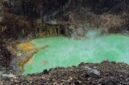 Pemandangan dramatis Kawah Putih Ciwidey dengan danau kawah berwarna kehijauan yang memukau, dikelilingi tebing-tebing putih dan diselimuti kabut tipis. Lanskap unik ini menjadi daya tarik utama bagi wisatawan yang mencari keindahan alam yang tak biasa.