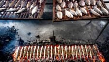Pemandangan otentik penjual surabi yang tengah membakar adonan di atas tungku arang tradisional, menunjukkan proses pembuatan yang menjaga keaslian rasa dan aroma khasnya. Asap tipis yang mengepul menambah nuansa hangat dari penganan legendaris khas Jawa Barat ini.