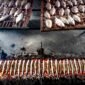 Pemandangan otentik penjual surabi yang tengah membakar adonan di atas tungku arang tradisional, menunjukkan proses pembuatan yang menjaga keaslian rasa dan aroma khasnya. Asap tipis yang mengepul menambah nuansa hangat dari penganan legendaris khas Jawa Barat ini.