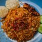 Sebuah mangkuk seblak Bandung disajikan hangat dengan beragam topping seperti ceker, bakso, dan kerupuk, memancarkan aroma pedas kencur yang menggugah selera. Hidangan ini menunjukkan perpaduan sempurna antara tekstur kenyal dan kuah pedas gurih yang menjadi daya tarik utama kuliner ikonik kota kembang.