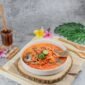 Seporsi seblak kuah pedas mengepul yang menggoda selera, dengan berbagai topping melimpah seperti bakso, sosis, dan ceker ayam, siap dinikmati. Hidangan ini memancarkan warna merah merona dari cabai dan aroma khas kencur yang menggugah selera para pencinta makanan pedas.