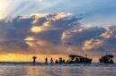 Indahnya siluet perahu nelayan tradisional saat matahari terbenam di Pantai Barat Pangandaran, menciptakan pemandangan ikonik yang menenangkan jiwa para pengunjung.