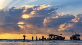 Indahnya siluet perahu nelayan tradisional saat matahari terbenam di Pantai Barat Pangandaran, menciptakan pemandangan ikonik yang menenangkan jiwa para pengunjung.