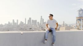 Seorang profesional urban melakukan meditasi di atap gedung pencakar langit, merefleksikan tren kaum urban 2026 yang mencari ketenangan di tengah hiruk-pikuk kota. Pemandangan ini menyoroti bagaimana individu menciptakan ruang personal untuk keseimbangan mental di lingkungan perkotaan yang dinamis.