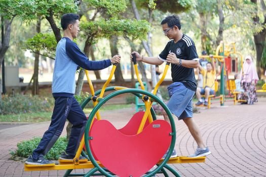 Sekelompok warga dengan antusias mengikuti sesi senam pagi di sebuah taman kota di Jawa Barat, menunjukkan semangat kebersamaan dan komitmen terhadap gaya hidup sehat. Mereka bergerak serentak di bawah bimbingan instruktur, menciptakan suasana ceria yang menular di tengah aktivitas pagi hari.