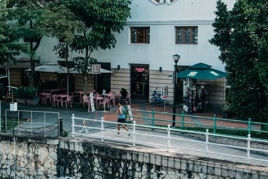 Seorang wanita melakukan yoga di rooftop dengan latar belakang gedung-gedung tinggi Jakarta, melambangkan upaya mencari ketenangan di tengah hiruk-pikuk kota metropolitan. Foto ini merefleksikan tren gaya hidup urban yang menyeimbangkan kesibukan dengan aktivitas relaksasi dan kesehatan.