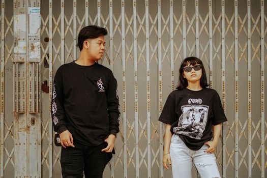 Sekelompok anak muda menunjukkan gaya mereka dengan percaya diri mengenakan pakaian dari merek-merek distro lokal, mencerminkan identitas dan kreativitas yang semakin mendominasi tren fashion di Indonesia. Desain unik dan orisinalitas produk distro menjadi daya tarik utama bagi generasi muda yang ingin tampil beda.