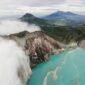 Pemandangan dramatis Kawah Putih dengan danau belerang berwarna putih kehijauan yang dikelilingi pepohonan Cantigi, menciptakan suasana magis nan menenangkan di Ciwidey, Bandung.