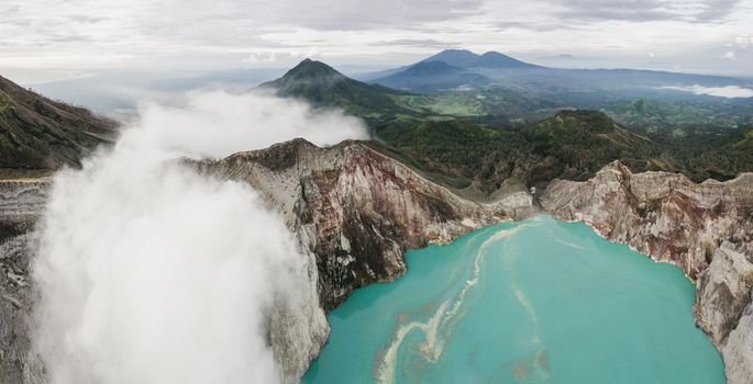 Pemandangan dramatis Kawah Putih dengan danau belerang berwarna putih kehijauan yang dikelilingi pepohonan Cantigi, menciptakan suasana magis nan menenangkan di Ciwidey, Bandung.