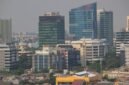Seorang individu melakukan meditasi di tengah lanskap kota Jakarta yang sibuk, menunjukkan bagaimana ketenangan dapat ditemukan di antara gedung-gedung tinggi. Pemandangan ini merefleksikan upaya banyak warga urban dalam mencari keseimbangan dan kebahagiaan di tengah kecepatan hidup perkotaan.