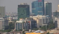 Seorang individu melakukan meditasi di tengah lanskap kota Jakarta yang sibuk, menunjukkan bagaimana ketenangan dapat ditemukan di antara gedung-gedung tinggi. Pemandangan ini merefleksikan upaya banyak warga urban dalam mencari keseimbangan dan kebahagiaan di tengah kecepatan hidup perkotaan.