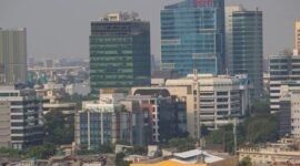 Seorang individu melakukan meditasi di tengah lanskap kota Jakarta yang sibuk, menunjukkan bagaimana ketenangan dapat ditemukan di antara gedung-gedung tinggi. Pemandangan ini merefleksikan upaya banyak warga urban dalam mencari keseimbangan dan kebahagiaan di tengah kecepatan hidup perkotaan.
