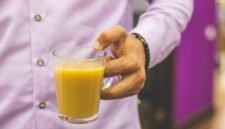 Seorang wanita sedang menikmati segelas jamu kunyit asam yang kaya rempah, mencerminkan perpaduan antara tradisi dan gaya hidup sehat modern. Minuman herbal ini semakin digemari sebagai alternatif alami untuk menjaga kesehatan tubuh.