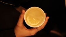 Secangkir teh hijau hangat mengepul dengan daun teh yang terlihat jelas, melambangkan minuman kaya antioksidan yang menyegarkan dan bermanfaat bagi kesehatan. Minuman ini telah lama menjadi bagian tak terpisahkan dari budaya hidup sehat di banyak belahan dunia.