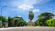 Seorang perempuan muda terlihat menikmati secangkir kopi hangat di balkon apartemennya di Jakarta, dengan latar belakang gedung pencakar langit yang menjulang tinggi, merefleksikan momen ketenangan di tengah hiruk pikuk perkotaan. Pemandangan ini menggambarkan bagaimana filosofi 
