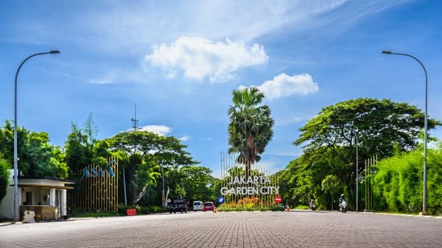Seorang perempuan muda terlihat menikmati secangkir kopi hangat di balkon apartemennya di Jakarta, dengan latar belakang gedung pencakar langit yang menjulang tinggi, merefleksikan momen ketenangan di tengah hiruk pikuk perkotaan. Pemandangan ini menggambarkan bagaimana filosofi 